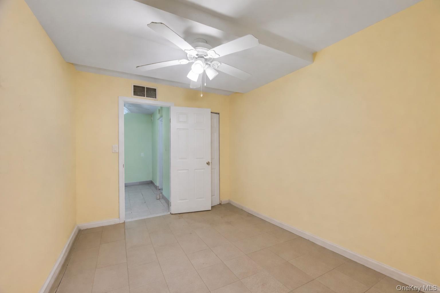 42-11 108th Street, Unit 1A Queens, NY 11368 - Photo 16 of 16 an empty room with a ceiling fan and a window