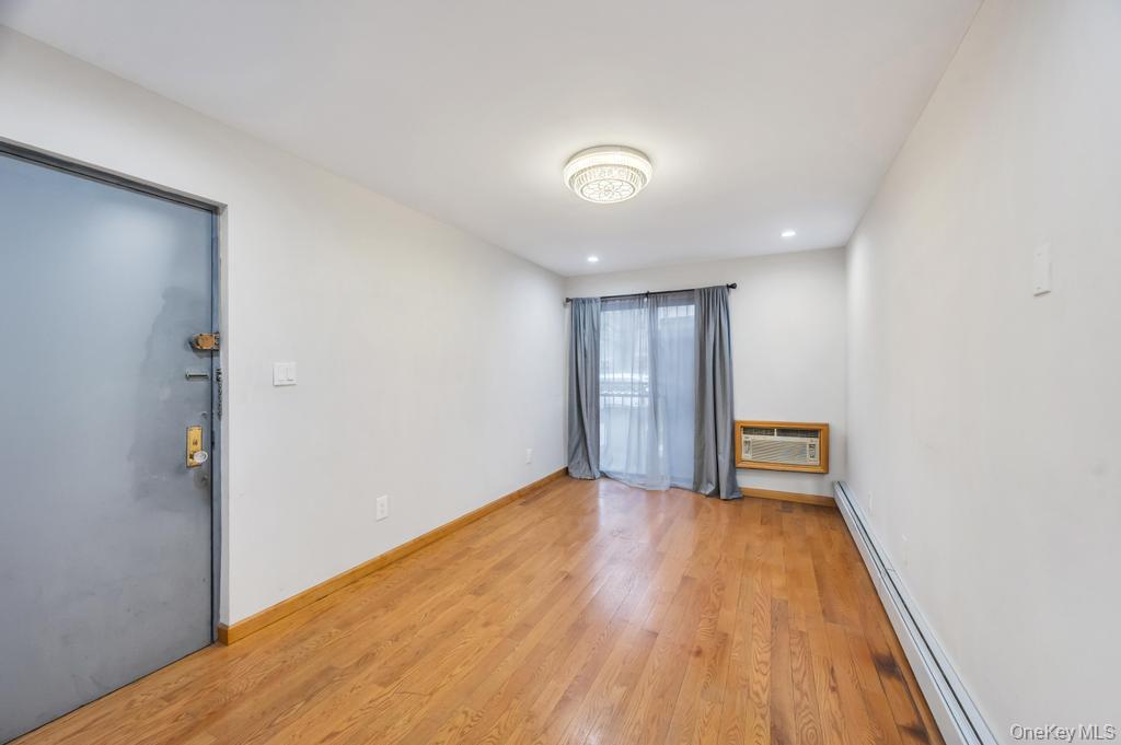 42-11 108th Street, Unit 1A Queens, NY 11368 - Photo 4 of 16 wooden floor in an empty room with a window