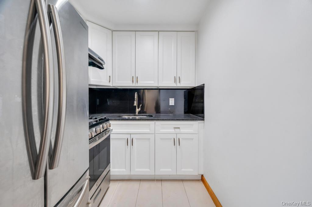 42-11 108th Street, Unit 1A Queens, NY 11368 - Photo 7 of 16 a kitchen with stainless steel appliances a refrigerator a stove a microwave and cabinets