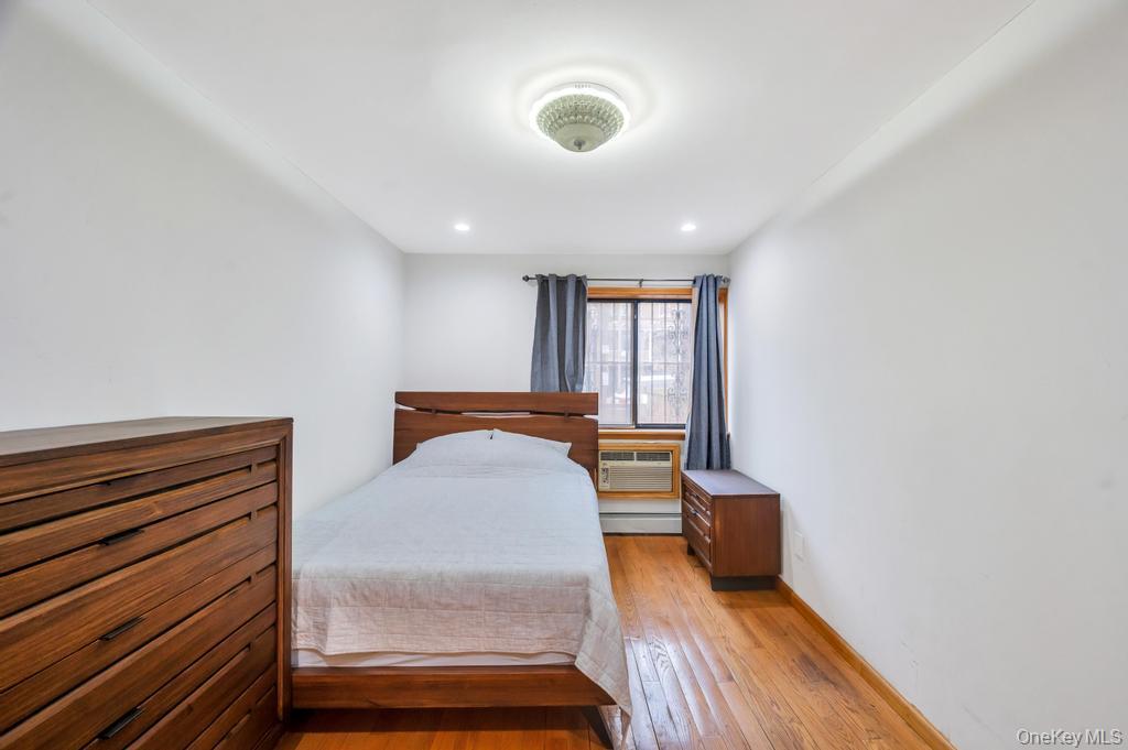 42-11 108th Street, Unit 1A Queens, NY 11368 - Photo 9 of 16 a bedroom with furniture and wooden floor