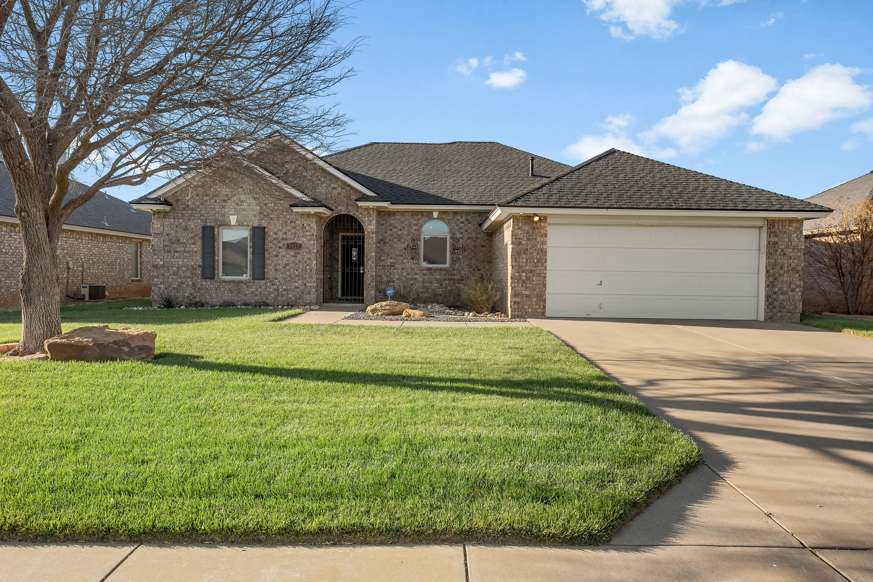 3017 104th Street Lubbock, TX 79423 - Photo 1 of 28 a front view of a house with a yard and garage