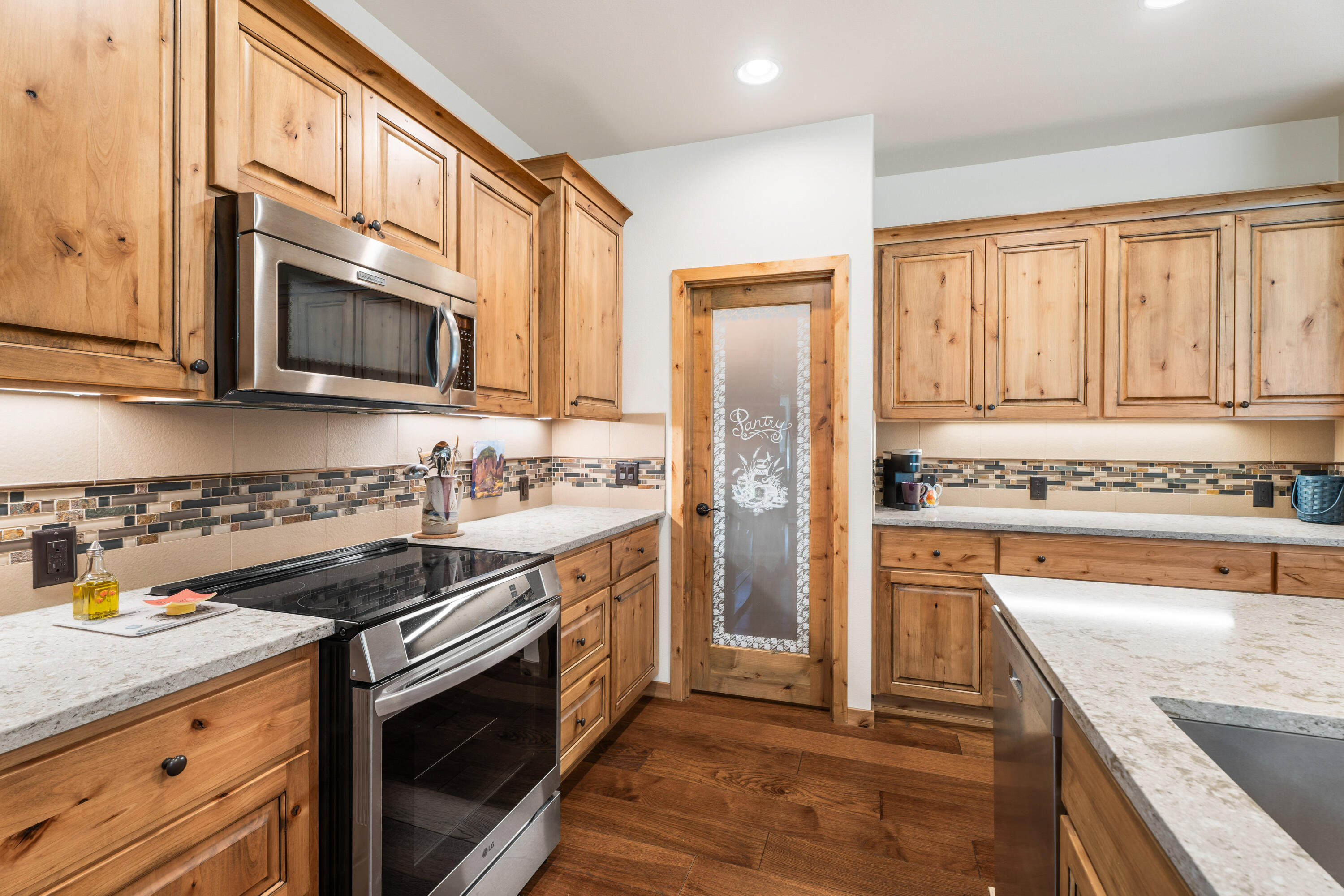 205 Vista Rim Drive Redmond, OR 97756 - Photo 11 of 85 a kitchen with stainless steel appliances granite countertop a stove microwave and cabinets