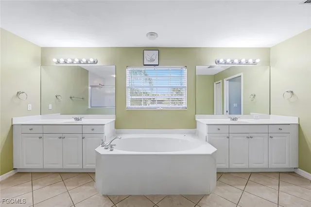 a large bathroom with a double vanity sink a large mirror and a shower