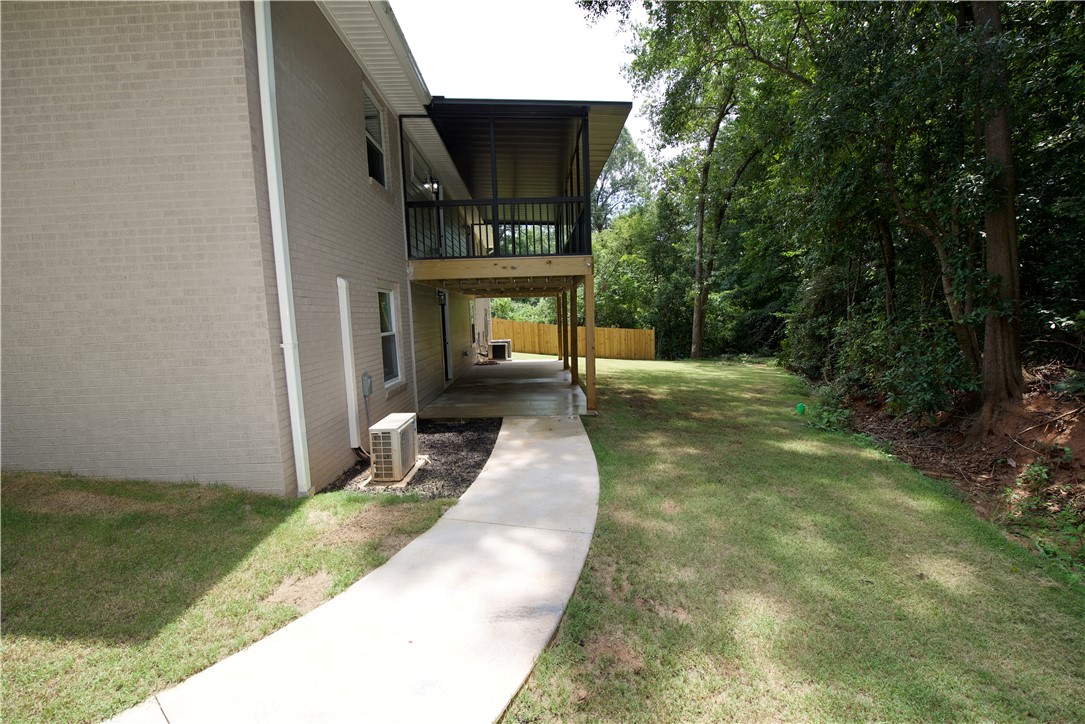 317 Pendleton Road Clemson, SC 29631 - Photo 5 of 36 A private, verdant yard extends from a two-story residence with an upper-level balcony and lower-level patio.
