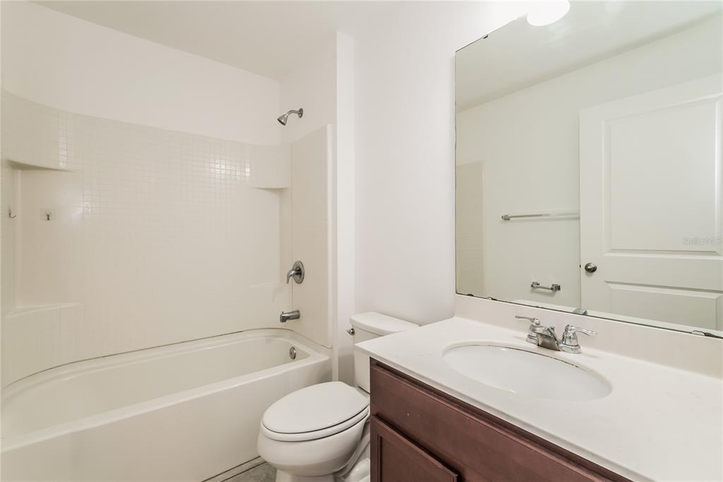 1473 Lucerne Loop Road Northeast Winter Haven, FL 33881 - Photo 21 of 25 a bathroom with a granite countertop sink a toilet and shower