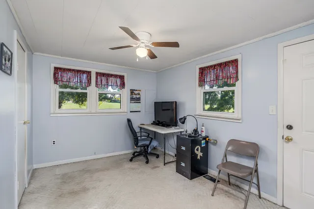 a view of a workspace with furniture and a window