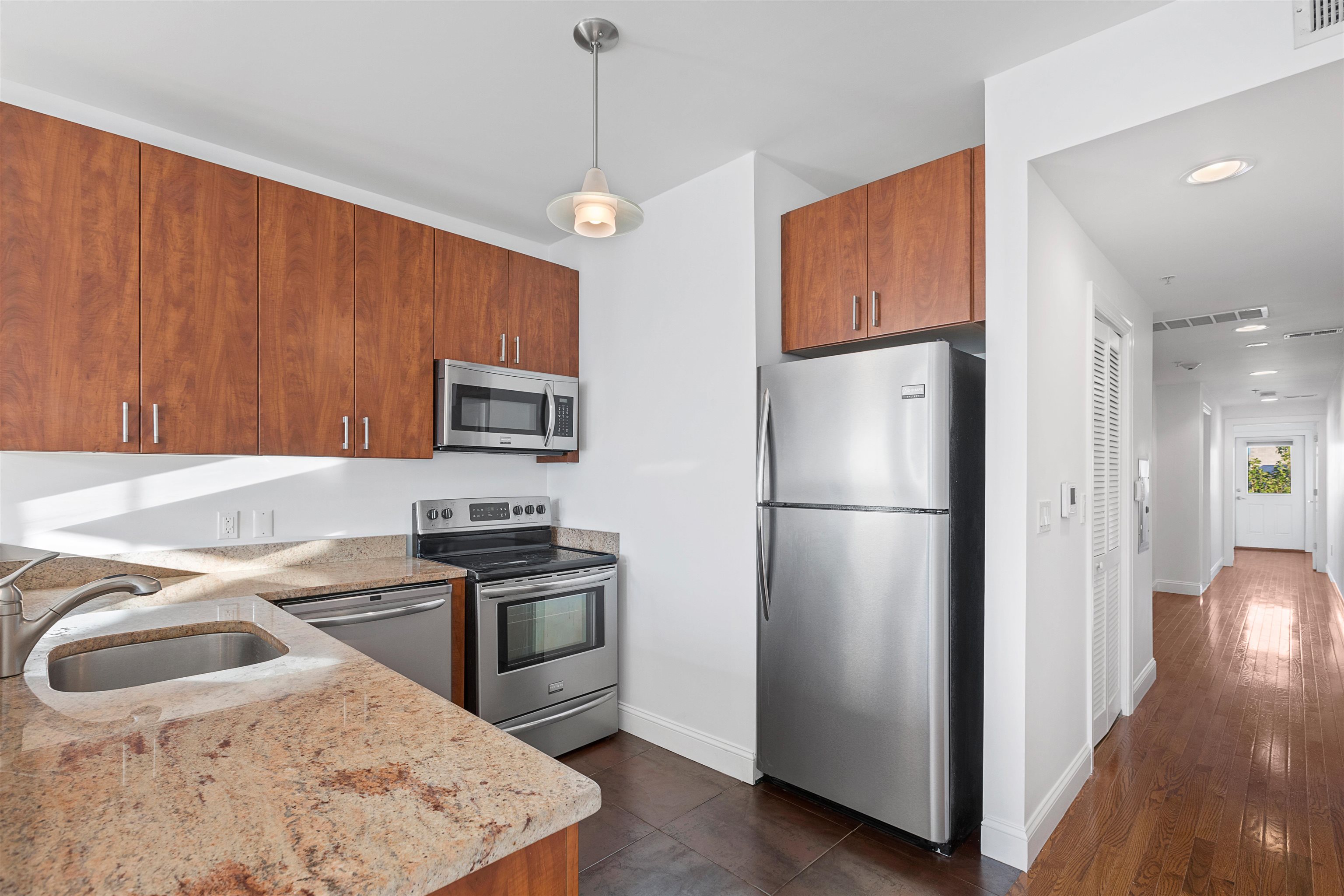 415 Jackson Street, Unit 4R Hoboken, NJ 07030 - Photo 1 of 13 a kitchen with stainless steel appliances granite countertop a refrigerator a sink dishwasher a stove with wooden floor and a dining table