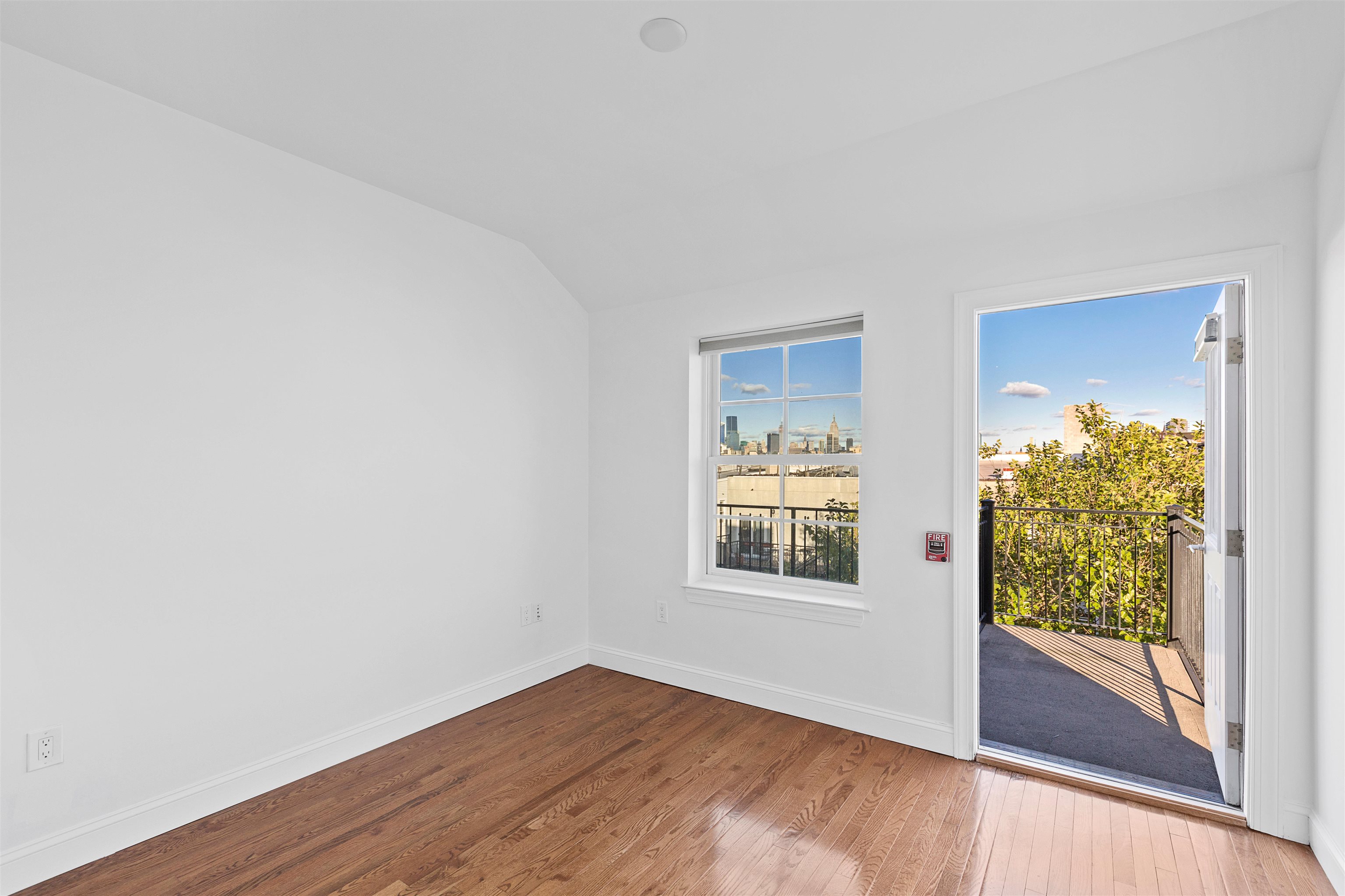 415 Jackson Street, Unit 4R Hoboken, NJ 07030 - Photo 7 of 13 an empty room with wooden floor and windows