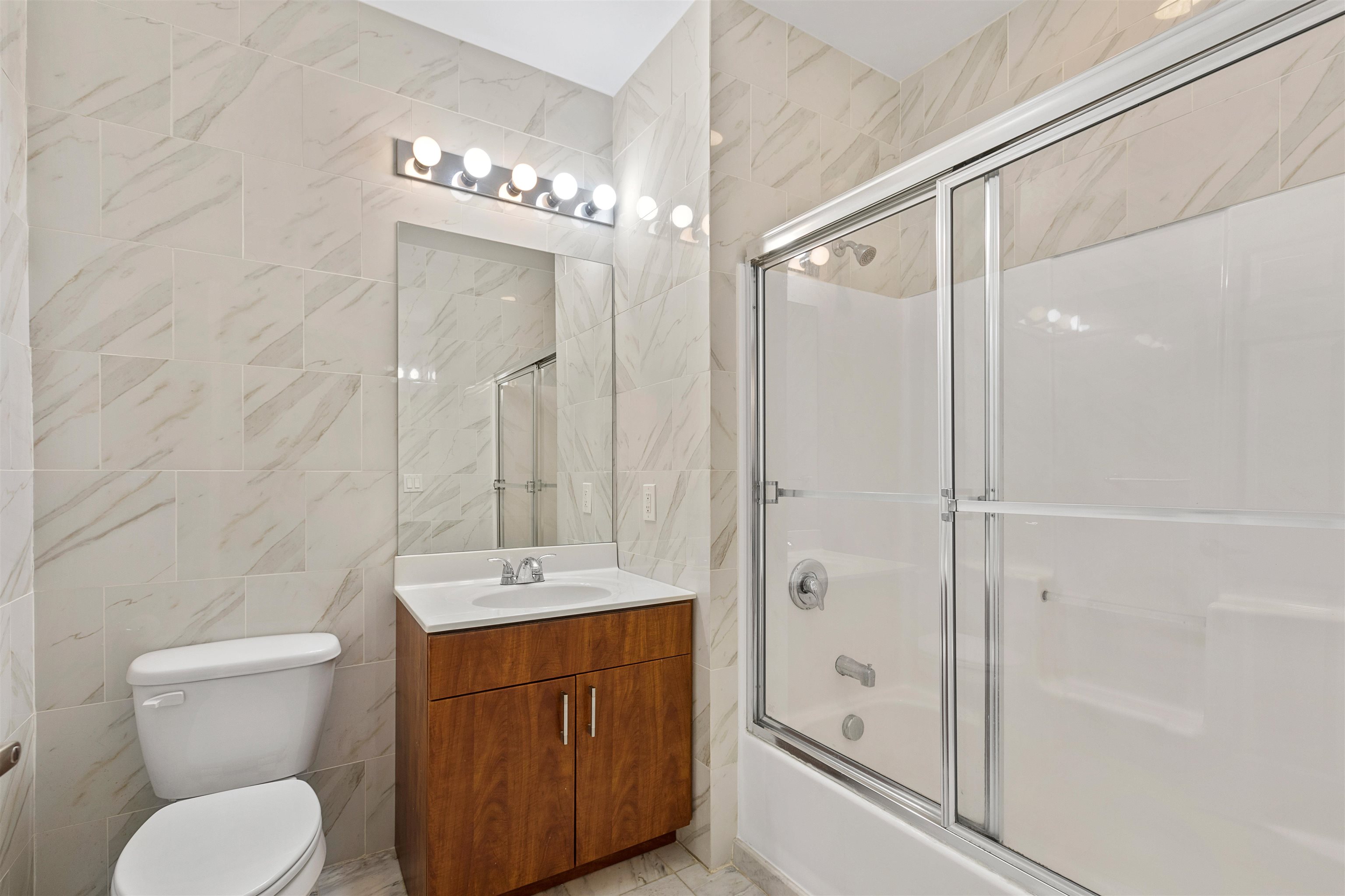 415 Jackson Street, Unit 4R Hoboken, NJ 07030 - Photo 8 of 13 a bathroom with a granite countertop sink a toilet a mirror and shower