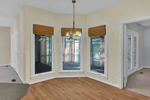 a view of an empty room with glass door and windows