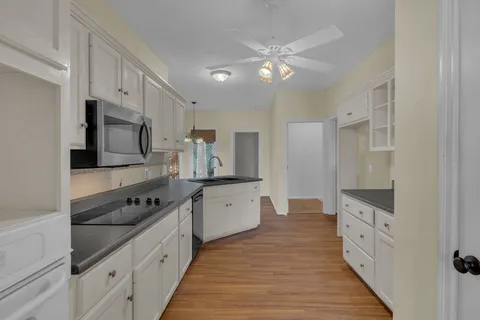 a large kitchen with cabinets and wooden floor