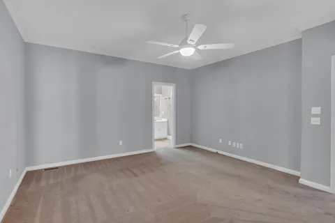 a view of an empty room with a chandelier fan
