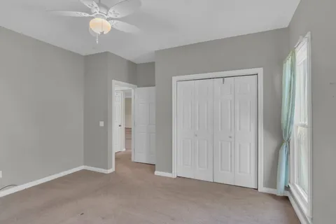 a view of an empty room and a ceiling fan