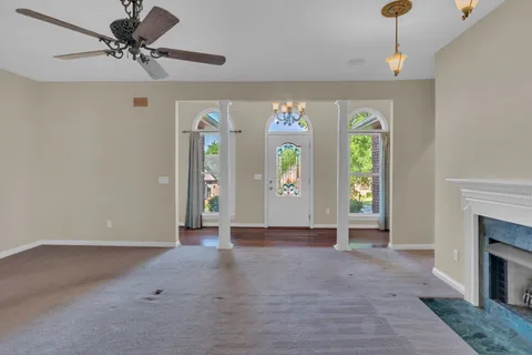 a view of an empty room with a window and a fireplace