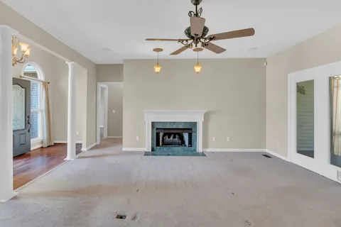 a view of an empty room with a fireplace and a window