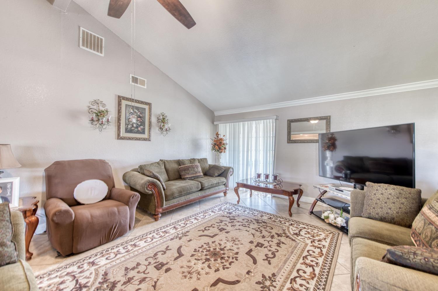 25540 Lynn Place, Unit B Madera, CA 93638 - Photo 12 of 37 a living room with furniture and a flat screen tv