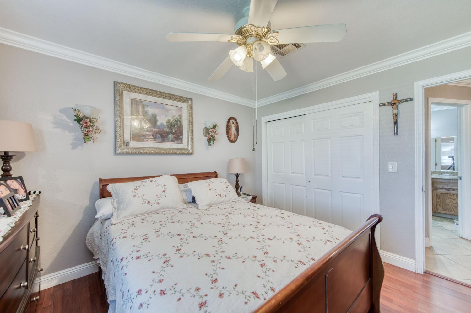 25540 Lynn Place, Unit B Madera, CA 93638 - Photo 16 of 37 a bedroom with a large bed and a chandelier
