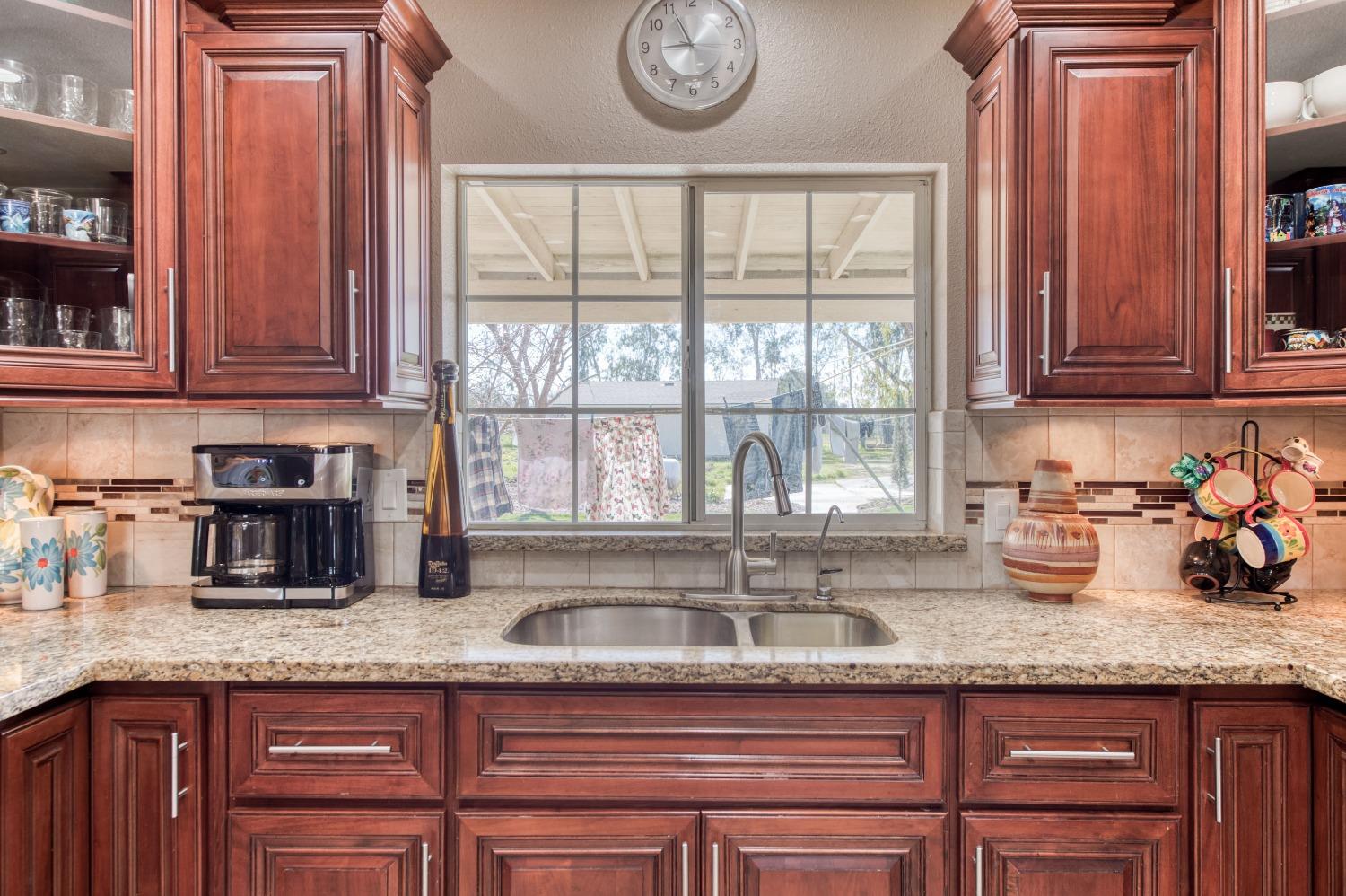 25540 Lynn Place, Unit B Madera, CA 93638 - Photo 9 of 37 a kitchen with granite countertop a sink a stove and cabinets