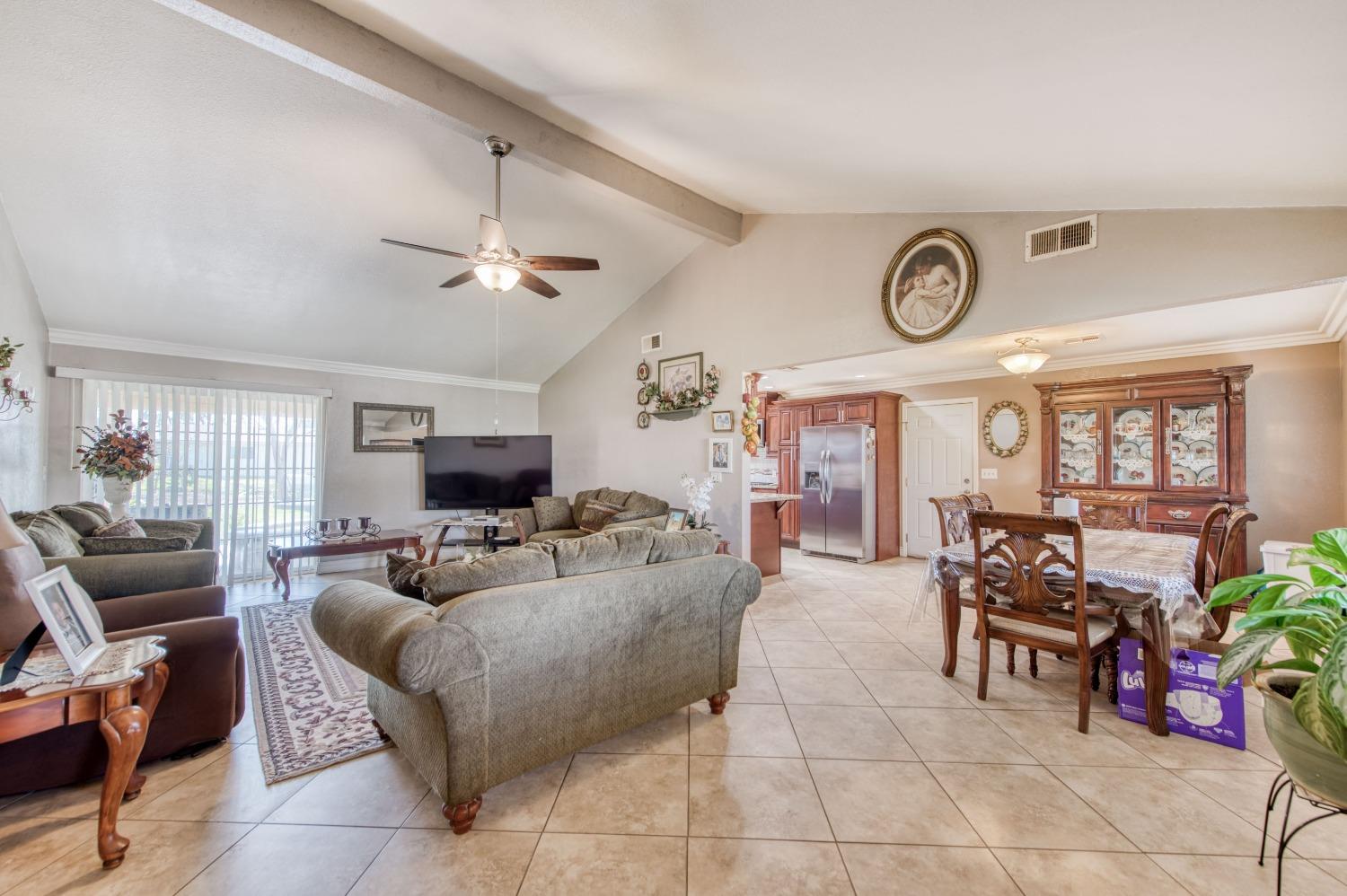 25540 Lynn Place, Unit B Madera, CA 93638 - Photo 10 of 37 a living room with furniture a large window and a clock