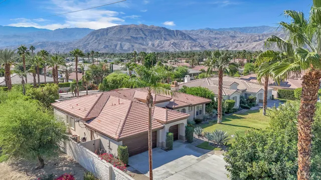 an aerial view of a house with a yard and mountain view