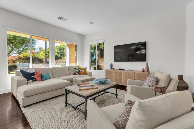 a open kitchen with stainless steel appliances granite countertop a sink dishwasher a dining table and chairs with wooden floor