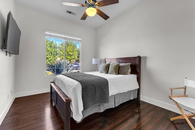 a spacious bedroom with a bed a couch and a chandelier