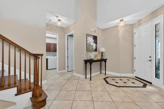a view of an empty room with window and chandelier fan