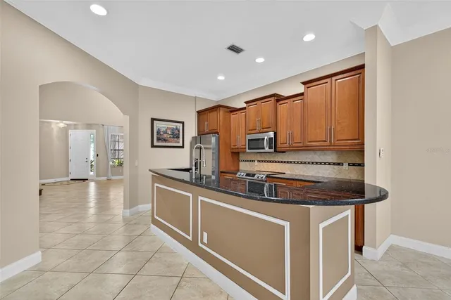 an empty room with wooden floor and a ceiling fan