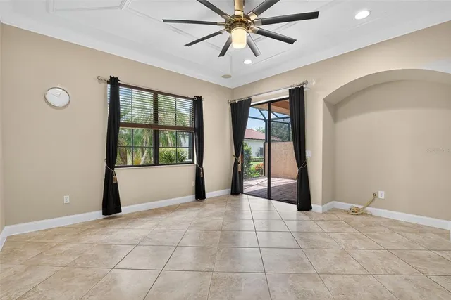 a view of empty room with wooden floor and ceiling fan