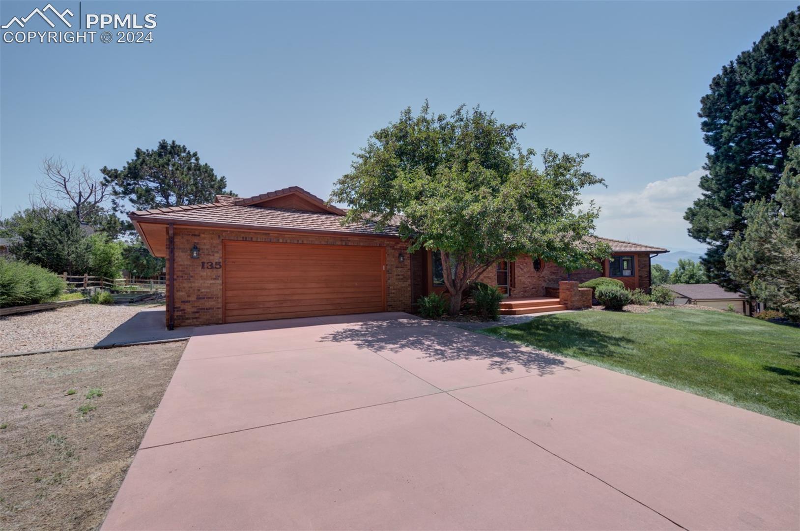 View of front of house featuring a garage and a front lawn