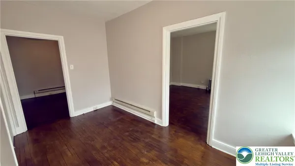 an empty room with wooden floor and closet