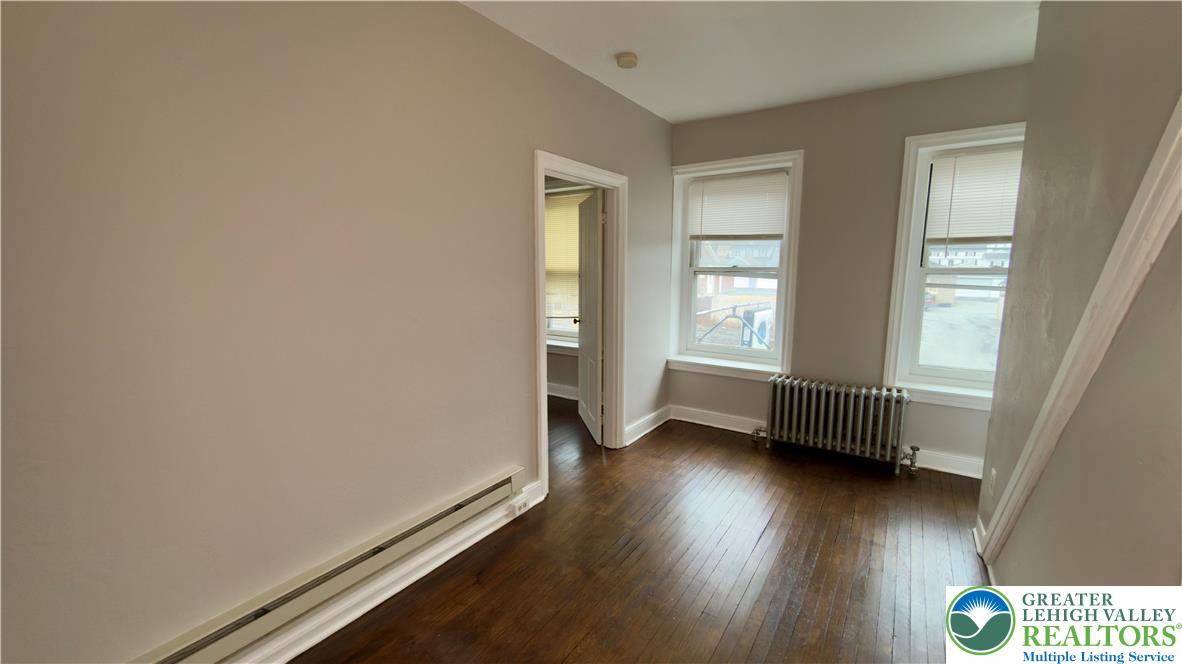 1236 Main Street, Unit 2 Hellertown, PA 18055 - Photo 10 of 29 an empty room with wooden floor and windows