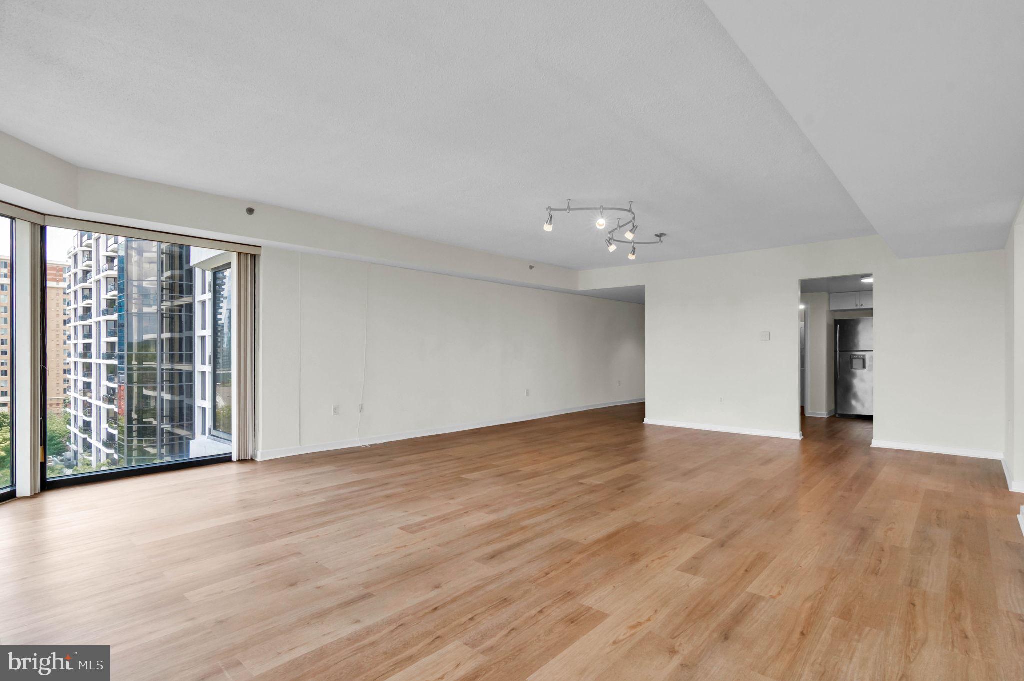 1530 Key Boulevard, Unit 715 Arlington, VA 22209 - Photo 16 of 41 a view of an empty room with wooden floor and a window