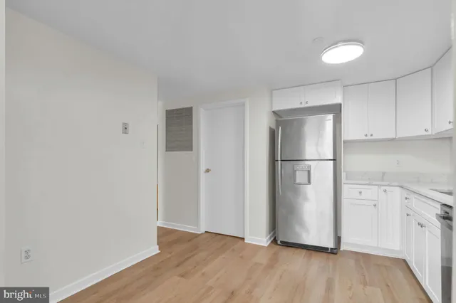 a view of a kitchen with wooden floor and electronic appliances
