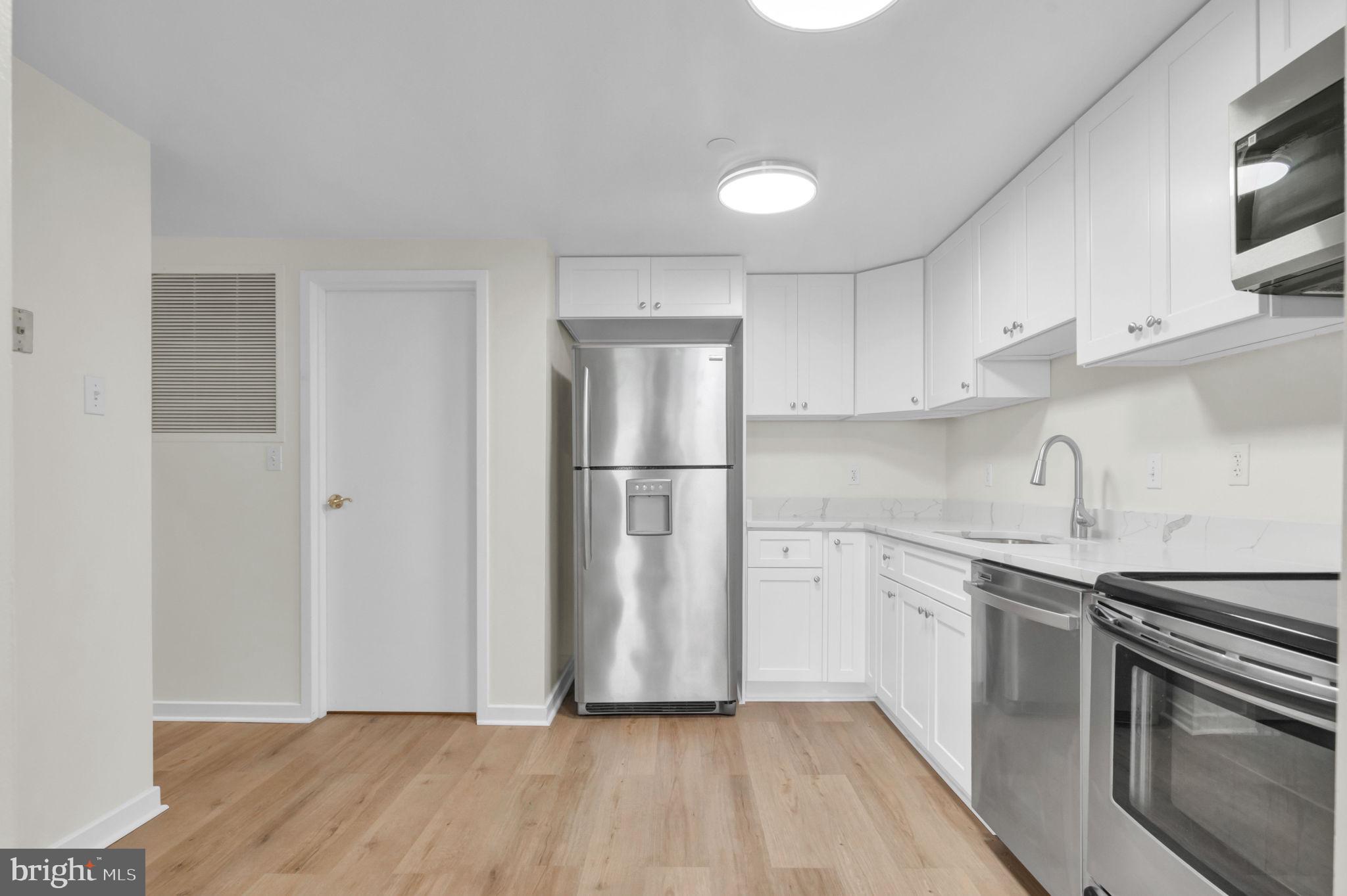 1530 Key Boulevard, Unit 715 Arlington, VA 22209 - Photo 10 of 41 a kitchen with stainless steel appliances granite countertop a stove a sink and a refrigerator
