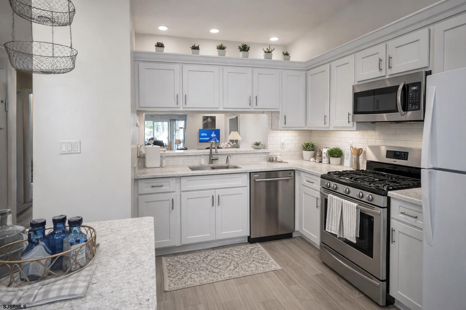 152 Club Place, Unit 152 Galloway Township, NJ 08205 - Photo 18 of 23 a kitchen with stainless steel appliances granite countertop a stove a sink and a microwave