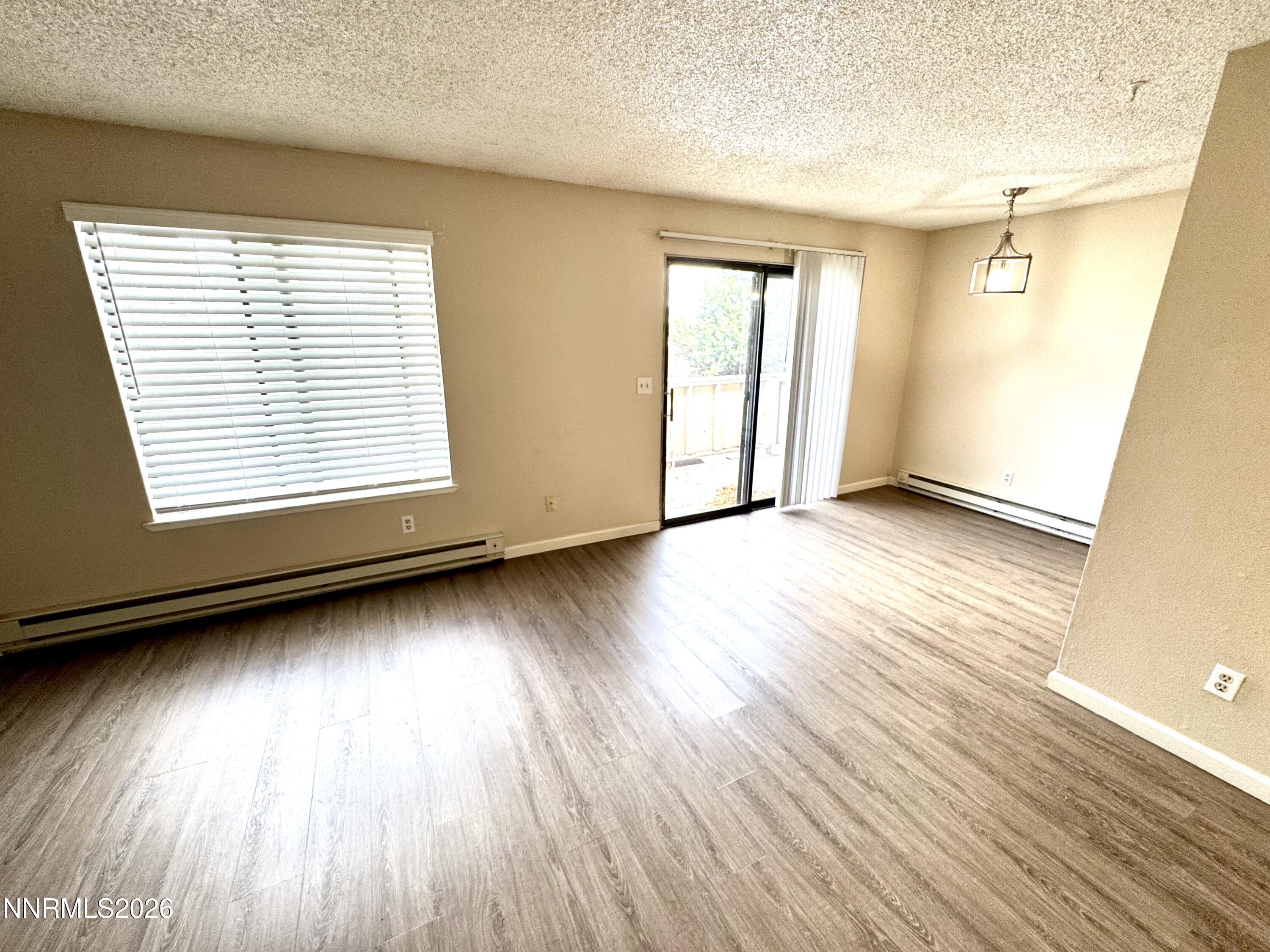 3880 East Leonesio Drive, Unit C2 Reno, NV 89512 - Photo 3 of 10 an empty room with wooden floor and windows