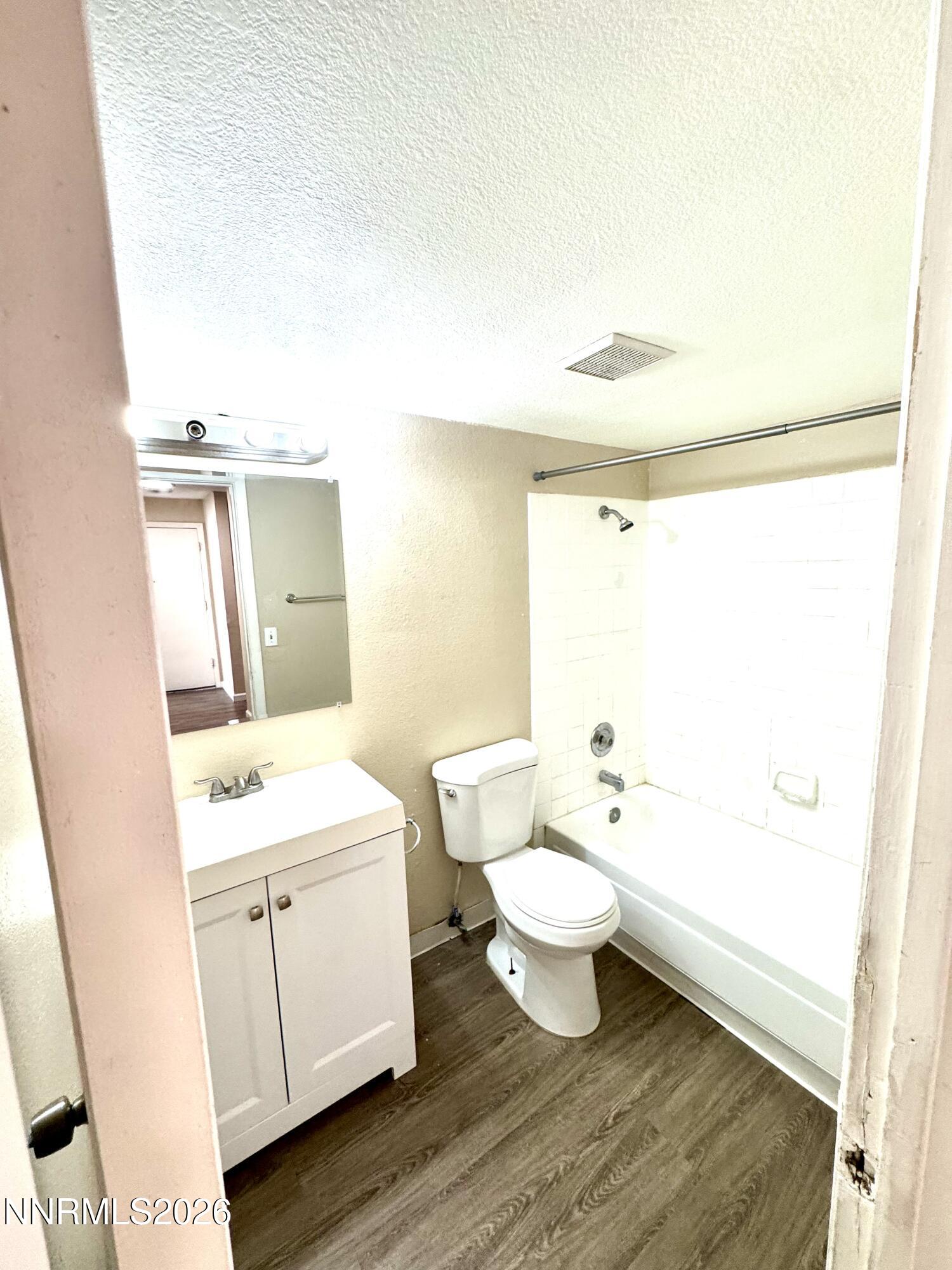 3880 East Leonesio Drive, Unit C2 Reno, NV 89512 - Photo 5 of 10 a bathroom with a toilet a sink and a mirror