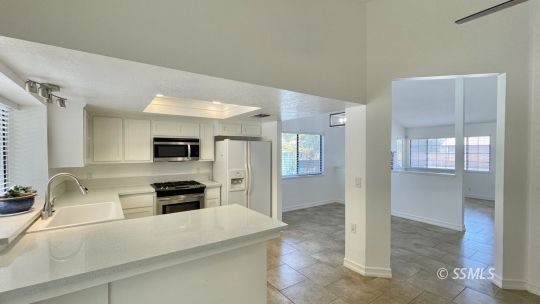 959 Jefferson Street Ridgecrest, CA 93555 - Photo 11 of 24 a kitchen with kitchen island a counter top space appliances and a sink