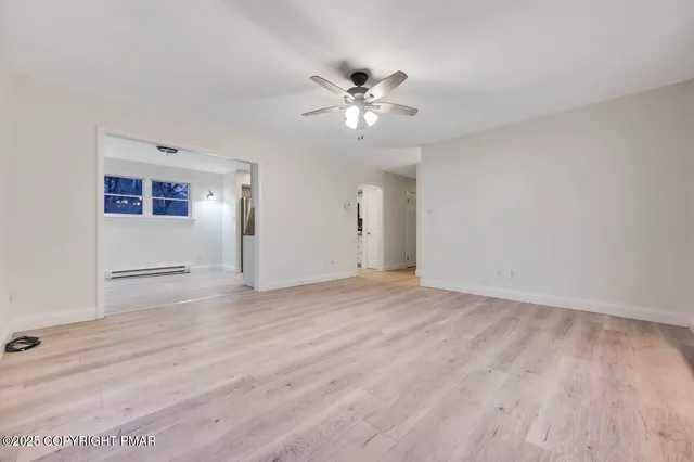 an empty room with wooden floor and window