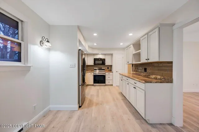 a view of a room with wooden floor and chandelier fan