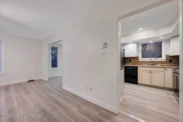 a view of an empty room with wooden floor