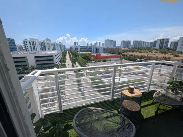 a view of a balcony with chairs and a potted plant
