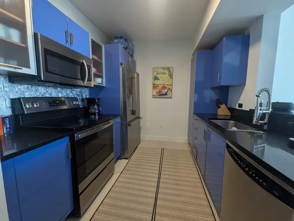 a kitchen with stainless steel appliances a stove microwave and sink