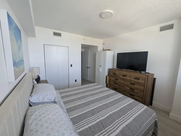 a bedroom with a bed and flat screen tv