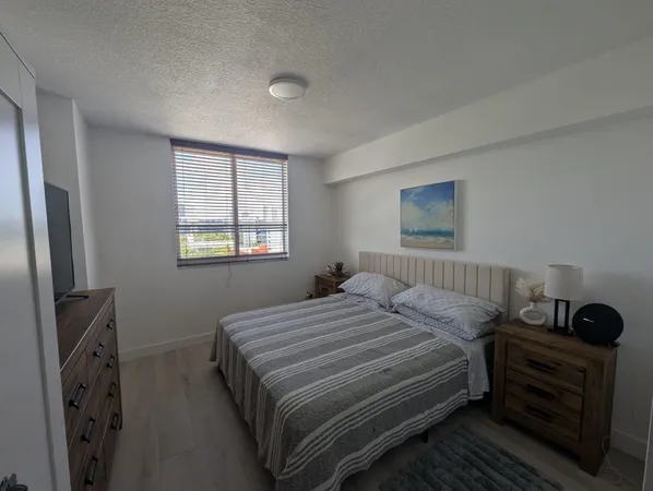 a bedroom with a bed next to a window