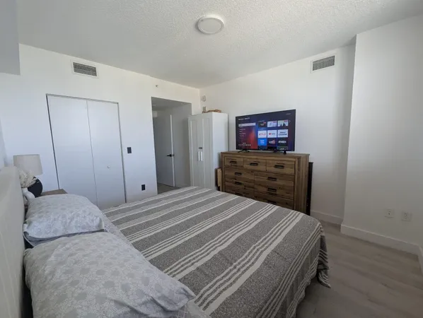 a bedroom with a bed and a flat screen tv