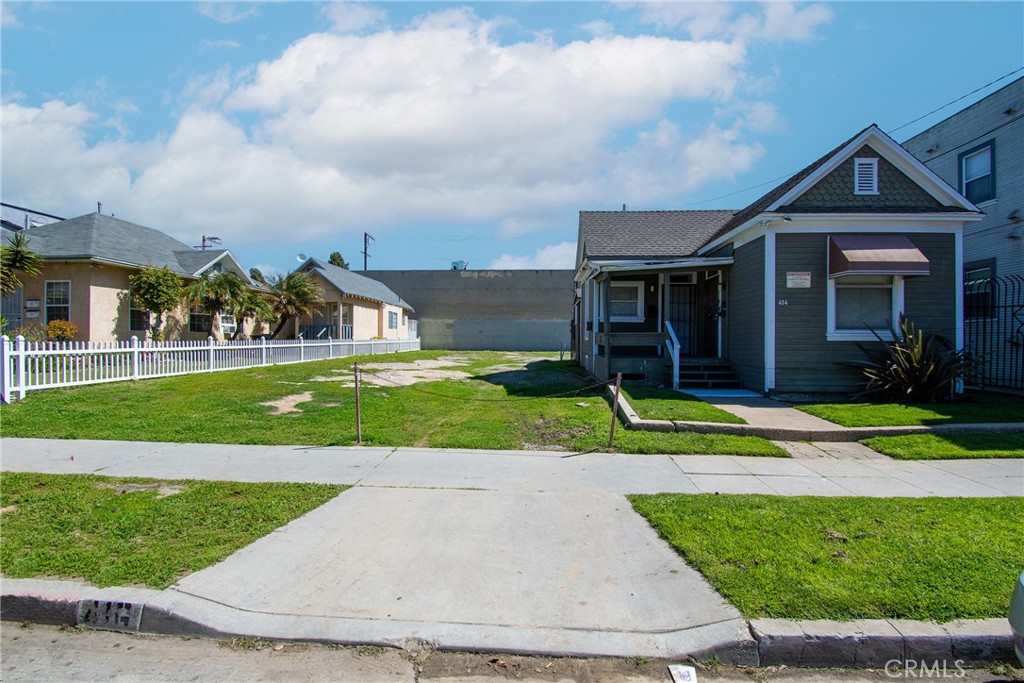 a view of a house with a big yard and potted plants
