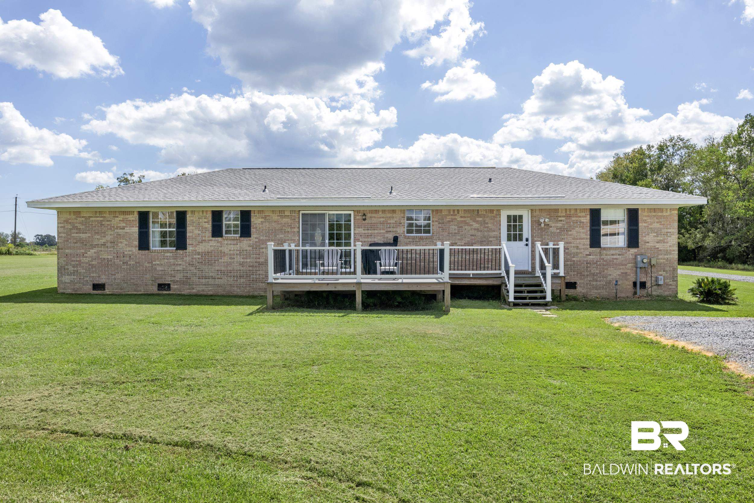 17689 Brewer Road Foley, AL 36535 - Photo 50 of 54 Back of house featuring a lawn and a deck