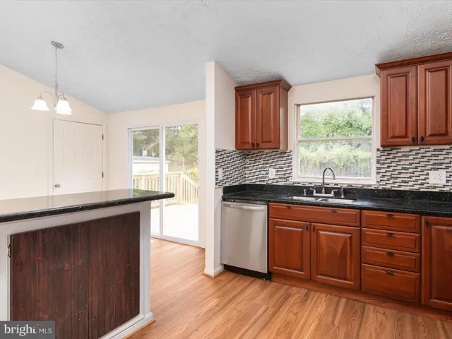 a kitchen with granite countertop wooden floors and sink
